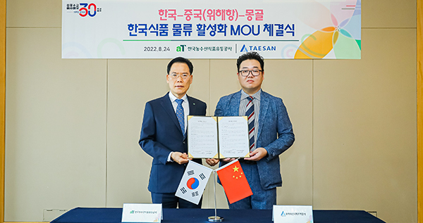 한국-중국(웨이하이)-몽골 K-Food 물류 활성화를 위한 업무협약식에서 박성국 aT 중국지역본부장(왼쪽)과 김윤재 웨이하이태산무역 대표가 포즈를 취하고 있다.(제공=aT)
