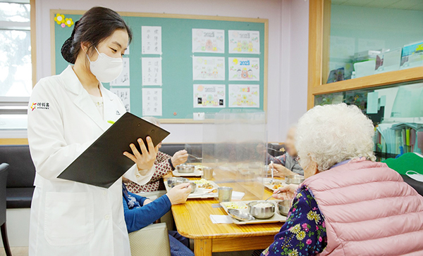 아워홈 영양사가 서울 마포구에 위치한 한서데이케어센터에서 ‘인지기능개선 관리 식단’을 시설 이용객에게 소개하고 있다.(제공=아워홈)